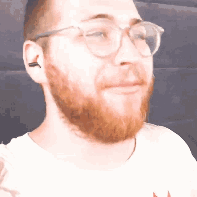 a man with a beard wearing glasses and a white shirt