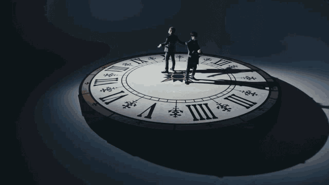 two people standing in front of a clock with the numbers xii on it