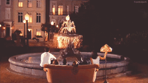a group of people sit on a couch in front of a fountain with the words centralpark below them