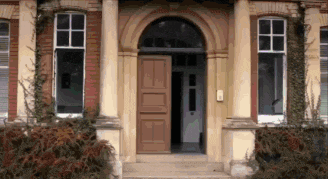 a brick building with a wooden door and steps