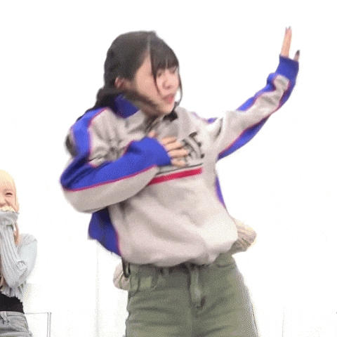 a woman wearing a supreme jacket is dancing in front of a group of people .