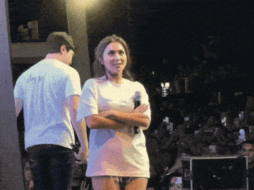 a man in a shirt that says joy is standing next to a woman in a white shirt