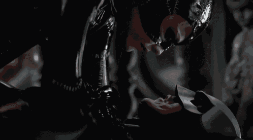 a woman in a catwoman costume kissing a man in a batman mask .