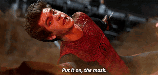 a man in a spider man costume is saying " put it on the mask "