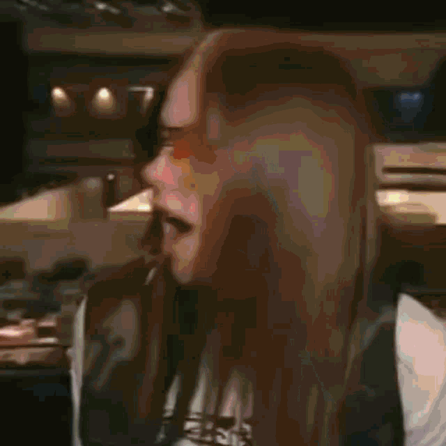 a woman wearing sunglasses and a necklace is making a face .