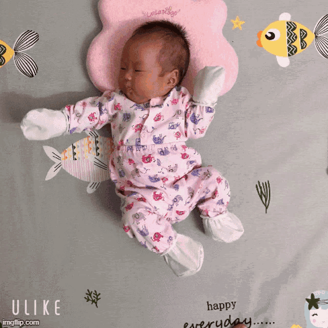 a baby laying on a blanket that says happy everyday on it