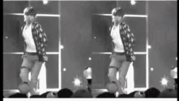 a man is dancing on a stage in front of a crowd .