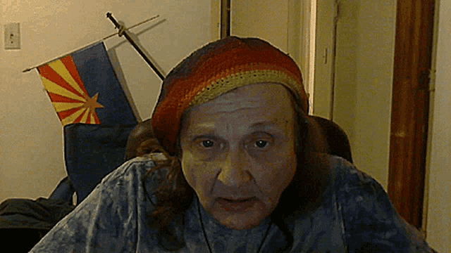 a man wearing a hat with a flag of arizona in the background