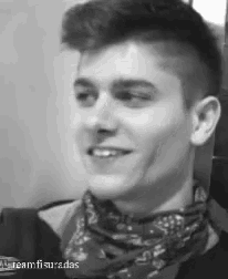 a black and white photo of a young man with a bandana around his neck