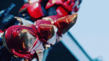 a close up of a red and gold statue with a blue sky in the background