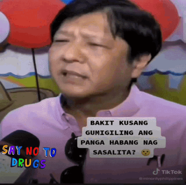 a man in a pink shirt is talking into a microphone with the words say no to drugs on the bottom