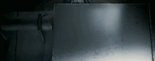 a person is welding a piece of metal in a dark room .