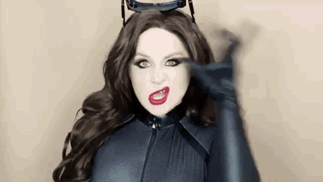 a woman in a catwoman costume is making a funny face and looking at the camera .