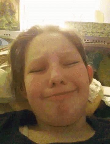 a close up of a person 's face with their eyes closed and smiling