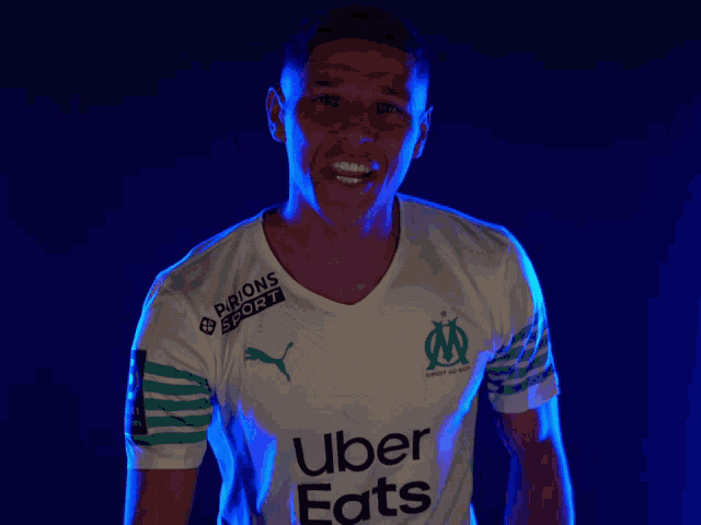 a man wearing a white shirt with uber eats on the front