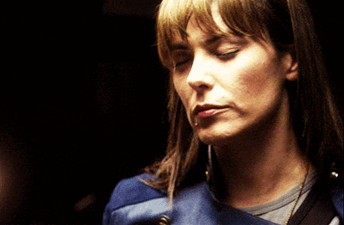 a close up of a woman 's face with her eyes closed and her mouth open