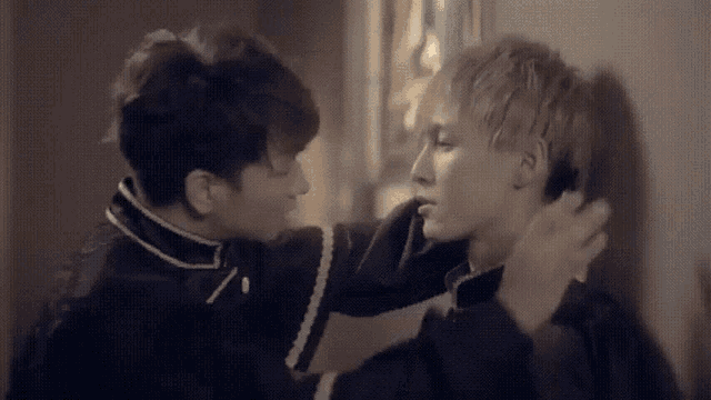 a couple of men are standing next to each other and one of them is touching the other 's neck .