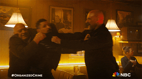 a poster for organized crime shows two men fighting in a restaurant