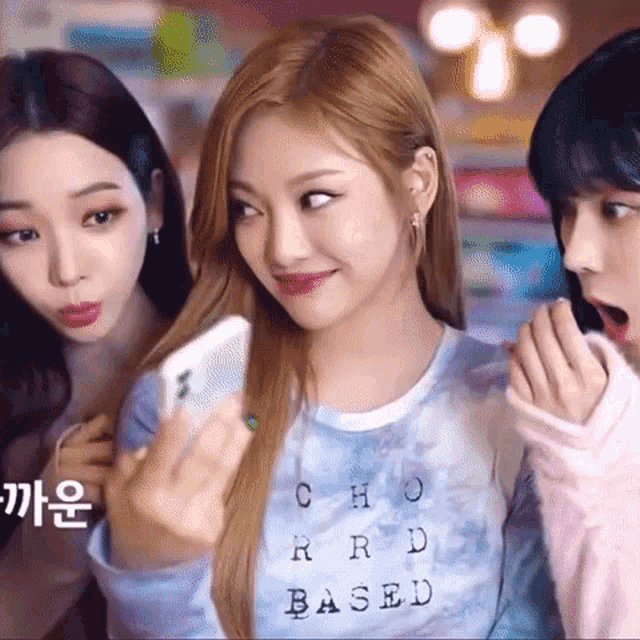 three girls are standing next to each other and one of them is wearing a shirt that says cho rrd based .