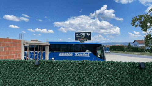 a blue zhutia tourist bus is parked in front of a brick building