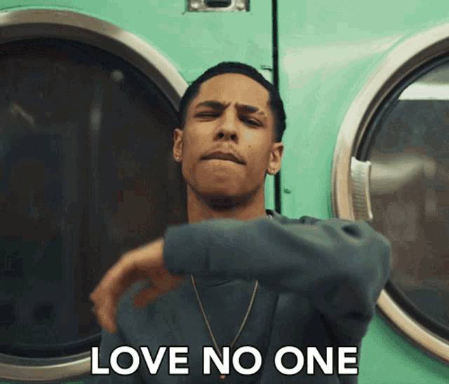 a man stands in front of a washing machine with the words love no one written on the bottom