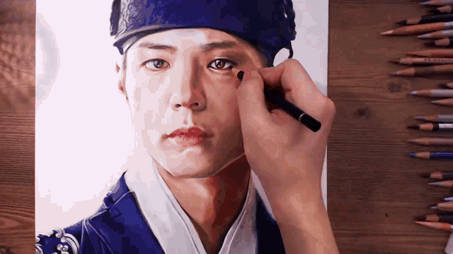 a person is drawing a man 's face with colored pencils including one that says prismacolor