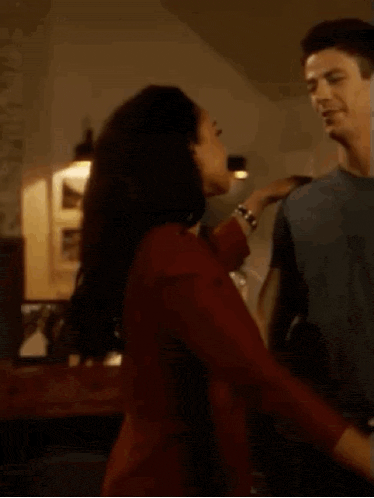 a man and a woman are dancing in a room .