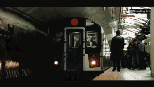 a subway station with a sign for boarding