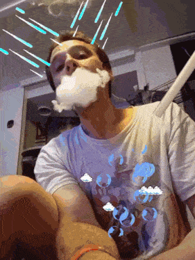 a man wearing a t-shirt with clouds on it is blowing bubbles out of his mouth