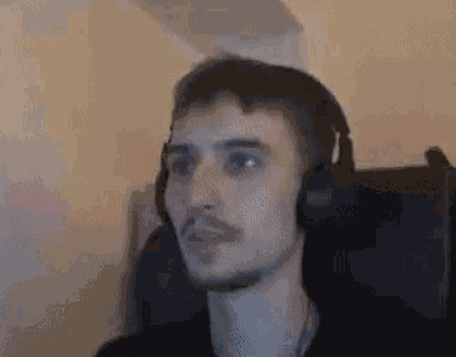 a man is wearing headphones and sitting in a chair .