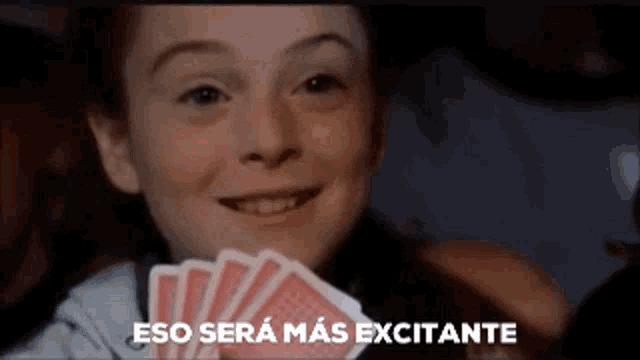 a girl holding a bunch of playing cards with the words " eso sera mas excitante " below her