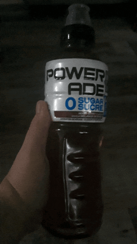 person holding a bottle of powerade sugar sucre