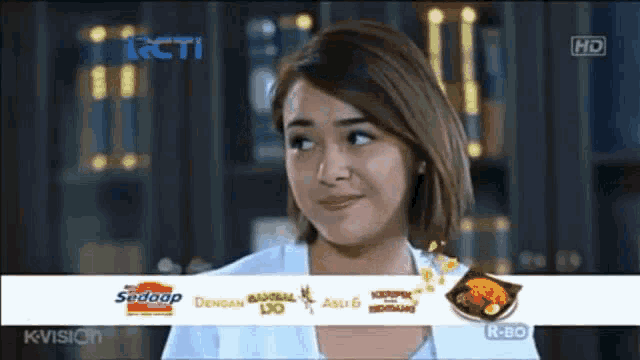 a woman is smiling in front of a rcti logo