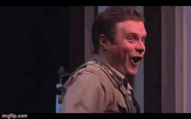 a man is making a funny face while standing on a stage .