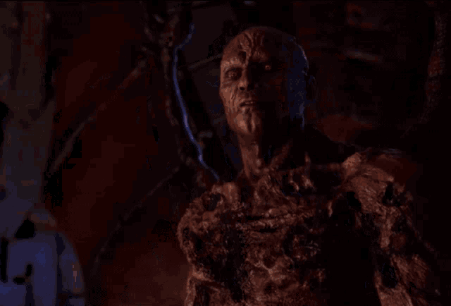 a group of people are standing around a statue of a monster