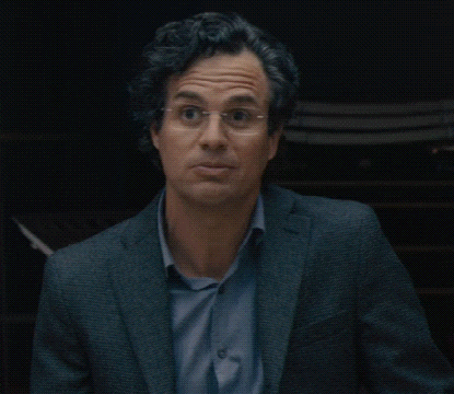 a man wearing glasses and a suit is looking at the camera