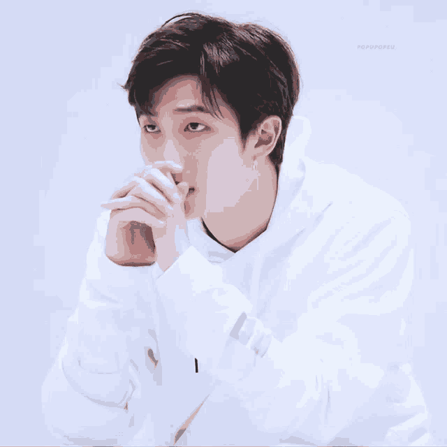 a young man wearing a white hoodie with the letter i on the sleeve