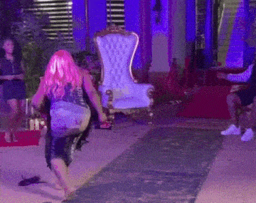 a man and woman are dancing in a room with purple lights and a sign that says could love .