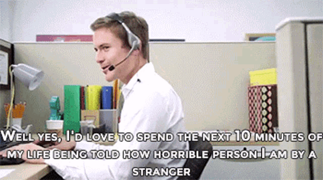 a man wearing a headset is sitting at a desk in an office