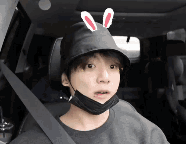 a young man wearing a black hat with bunny ears on it