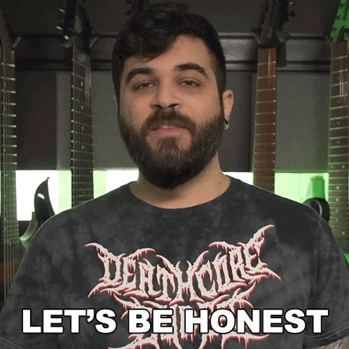 a man with a beard is wearing a black shirt that says " let 's be honest "