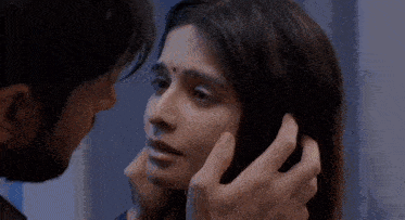 a man is touching a woman 's face with his hands