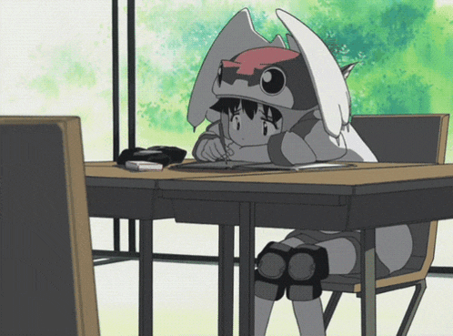 a girl in a bunny costume sits at a desk with her head resting on her knees