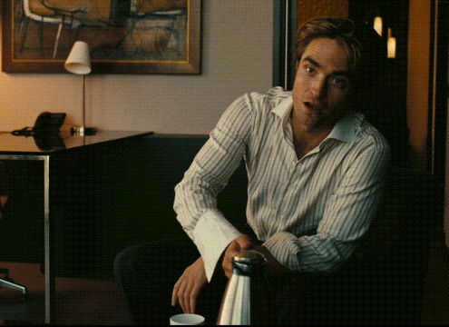 a man in a striped shirt sits in front of a table