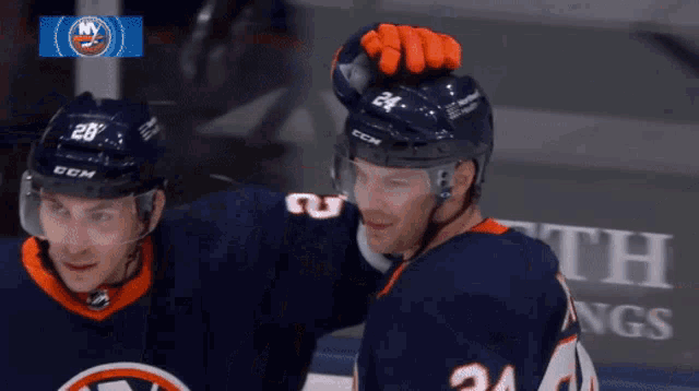 a hockey player with the number 24 on his jersey is standing next to another player