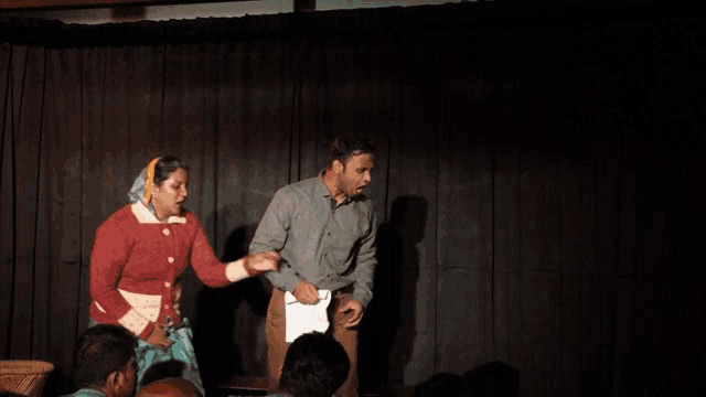 a man and a woman are standing on a stage