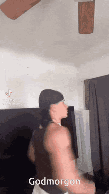a man is dancing in a room with a ceiling fan and says godmorgen