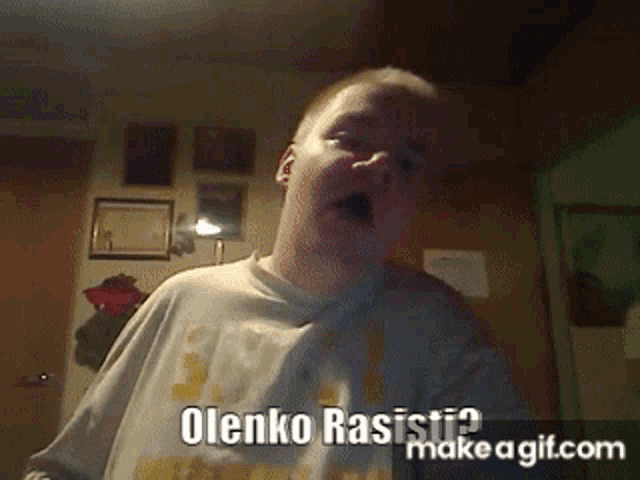 a young boy is making a funny face with the words olenko rasisti on the bottom right