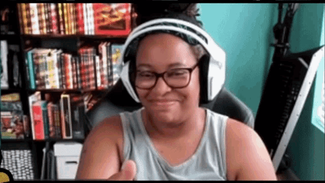 a woman wearing headphones giving a thumbs up