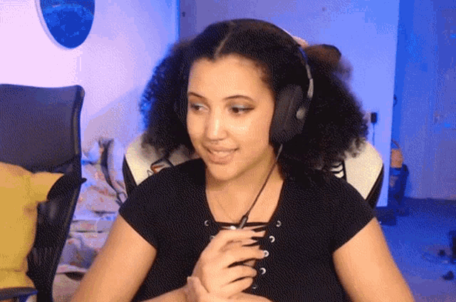 a woman wearing headphones is sitting in a chair and smiling